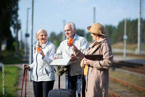 A group of happy senior with suitcases and glasses of coffee, a group of friends traveling
