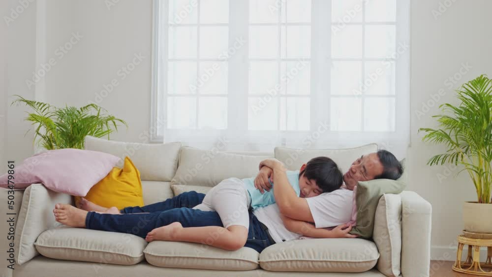Father and son hugging on the sofa in a happy Asian family. love and care, enjoying time together, Father's Day. Parents 44 with Children 7 years Father and son hugging on the sofa in a happy Asian family. love and care, enjoying time together, Father's Day. Parents 44 with Children 7 years