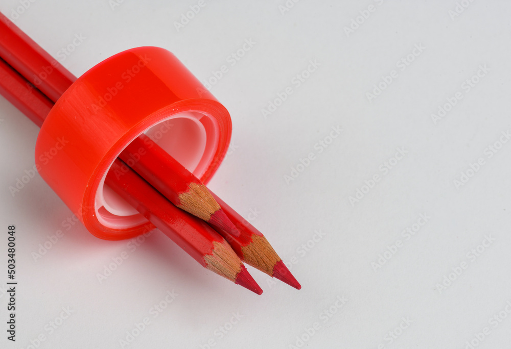 Red adhesive tape and red pencils Red adhesive tape and red pencils