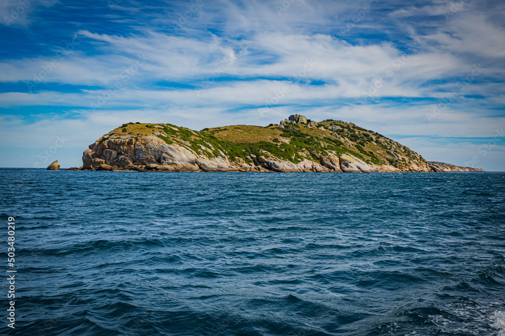 Isolated island seascape in Cruising tour view in the Bass Strait at Wilson Promontory Victoria Australia, with blue sea and sky