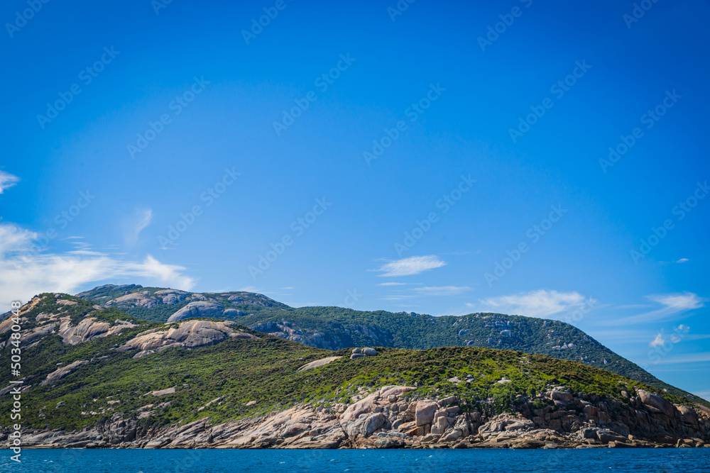 Stone rock mountain forest seascape in Cruising tour view in the Bass Strait at Wilson Promontory Victoria Australia, blue sky and blue sea