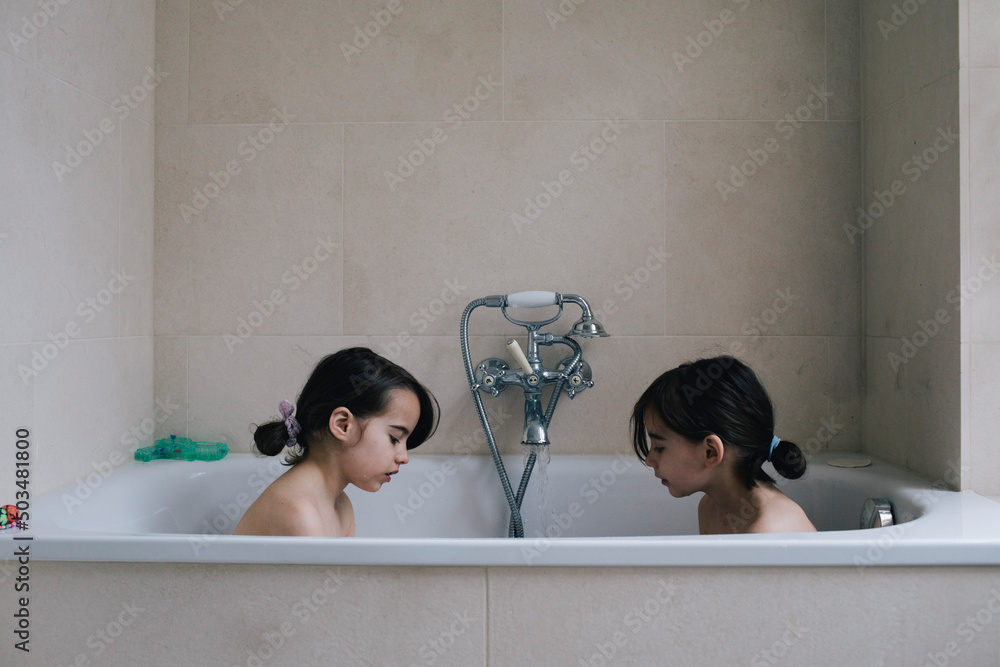 Twin sister bathing together in bathtub at home Stock Photo Adobe Stock