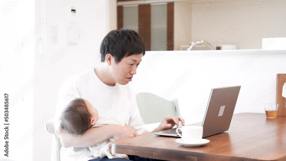育児をしながら家で仕事をしている男性 育児をしながら家で仕事をしている男性