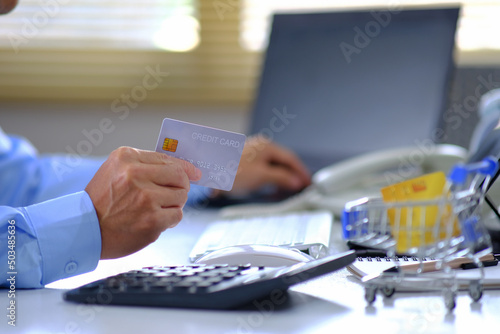 Online Payments  Businessman Hand Using Credit Card Payments  Online Payments Human hands handle credit cards and utilize a laptop to shop online.
