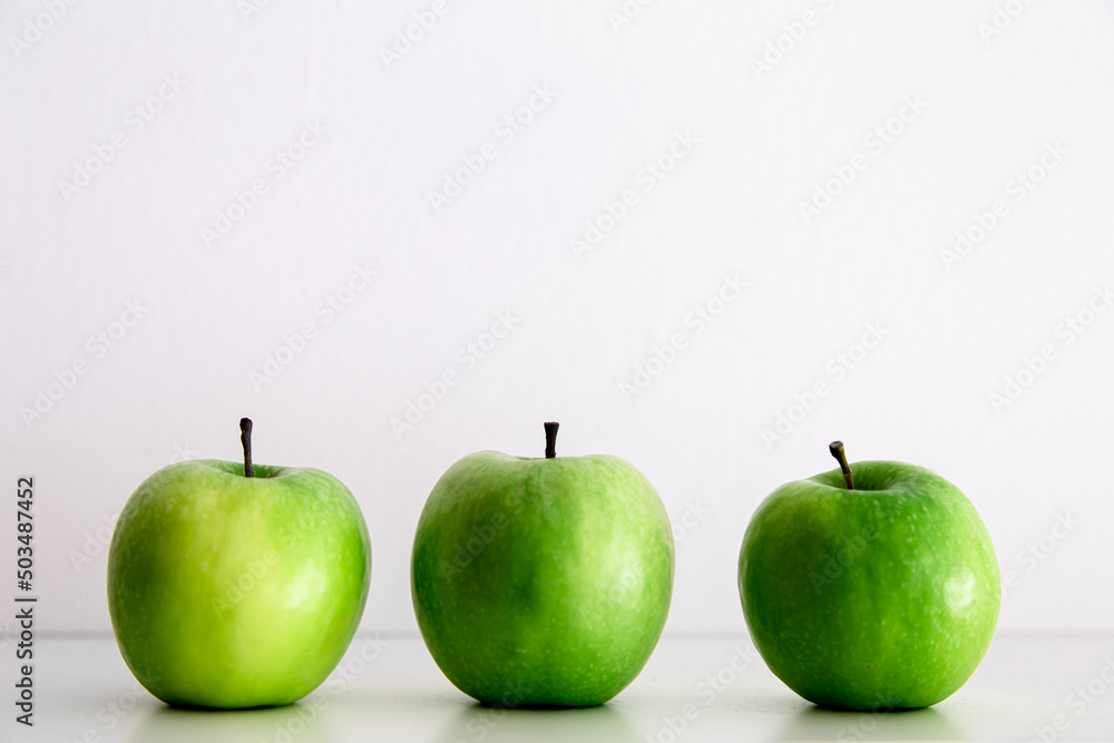 Green apples on a white background close-up. Green apples on a white background close-up.