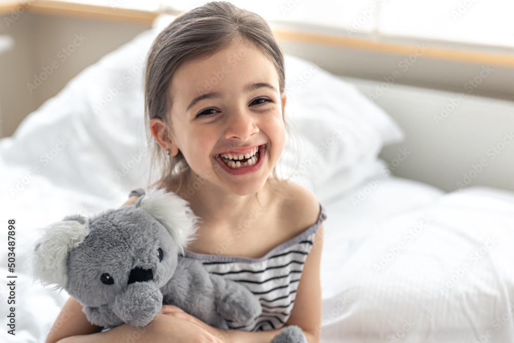 Happy little girl with soft toy koala in bed. Happy little girl with soft toy koala in bed.