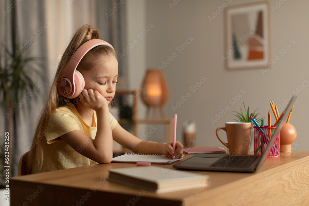 Tired Schoolgirl Learning Online Using Laptop And Taking Notes Indoor Tired Schoolgirl Learning Online Using Laptop And Taking Notes Indoor