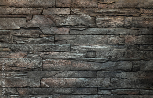 Soft light on pieces of Stone cladding wall. made of striped stacked slabs of natural brown rocks for walls texture and background, Copy space, Selective focus. photo