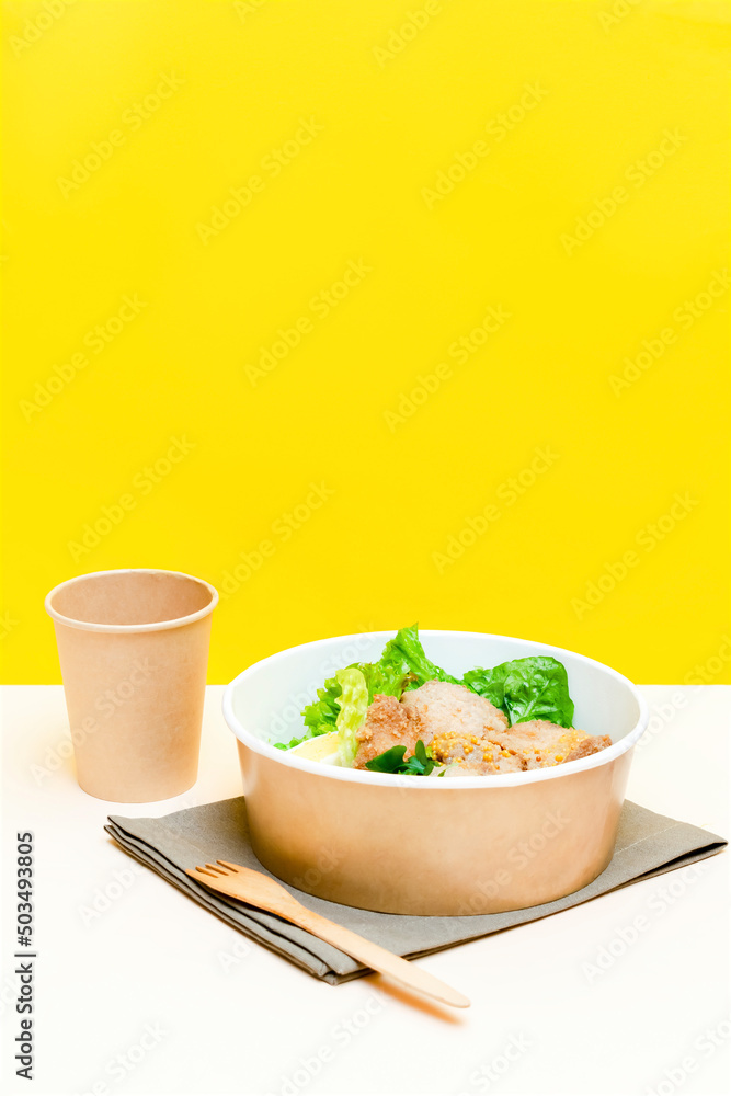 Healthy food lunch in kraft paper carton eco friendly box disposable bowl packaging container, cup on yellow background. chicken, eggs, greens. Take away delivery. environment protection, vertical Healthy food lunch in kraft paper carton eco friendly box disposable bowl packaging container, cup on yellow background. chicken, eggs, greens. Take away delivery. environment protection, vertical