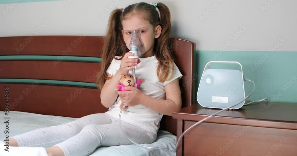 Girl making inhalation with nebulizer at home.
Girl making inhalation with nebulizer at home.