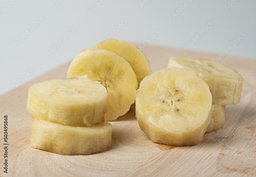 Closeup sliced banana on wood with white background. Closeup sliced banana on wood with white background.