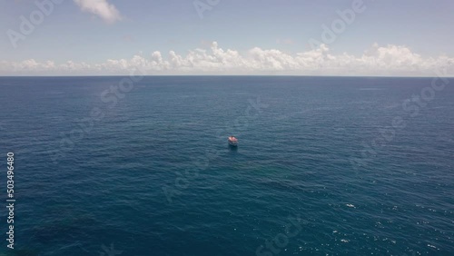 Blue ocean and a fishing boat. in tropical waters. Nothing but water and the horizon.  photo