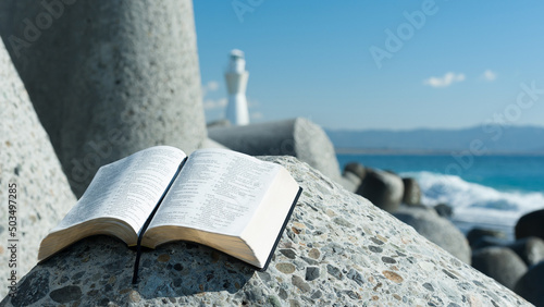 Fotografi Holy Bible open to Psalm 119 on top of a breakwater
