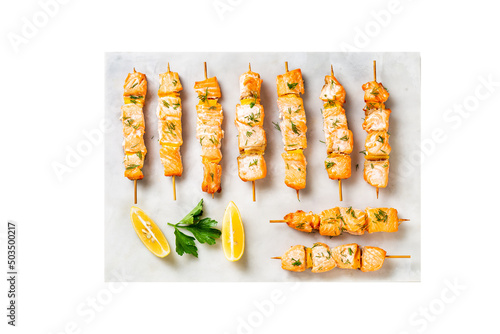 Grilled salmon fish kebabs on the white plate