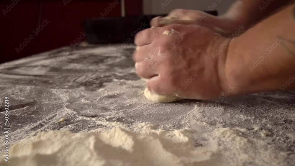Men's hands hold dough. making raw dough for pizza, rolls or bread. Handmade. Wheat pastries in bakery products. Production of bakery products. Men's hands knead dough. protven or countertop. Men's hands hold dough. making raw dough for pizza, rolls or bread. Handmade. Wheat pastries in bakery products. Production of bakery products. Men's hands knead dough. protven or countertop.