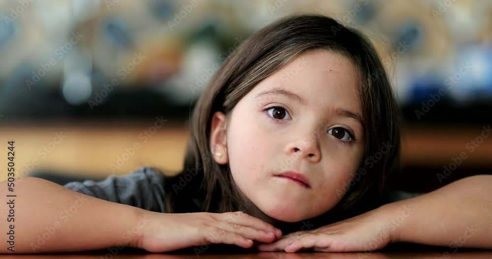 Cute small girl portrait face looking at camera child leaning on table closeup face Cute small girl portrait face looking at camera child leaning on table closeup face