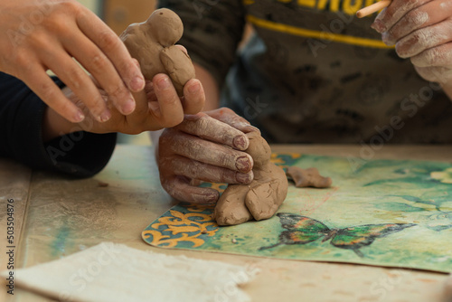 a child makes clay crafts with his hands