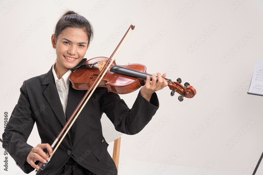 In violin practice class,two beautiful woman hold wooden violin.teach and practice playing violin together to prepare for the concert. In violin practice class,two beautiful woman hold wooden violin.teach and practice playing violin together to prepare for the concert.