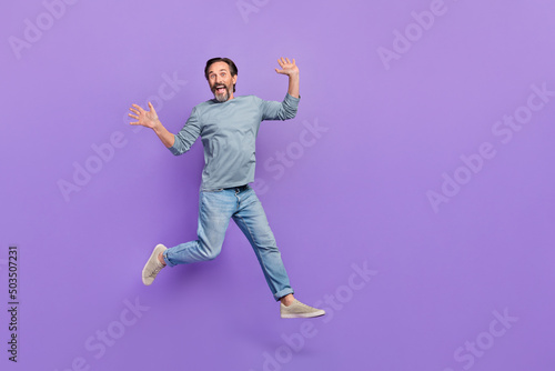Full body photo of cheerful aged man have fun jumper wear casual clothes isolated over purple color background