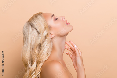 Profile side photo of stunning adorable lady touch neck lifting anti age wrinkles correction isolated on beige color background