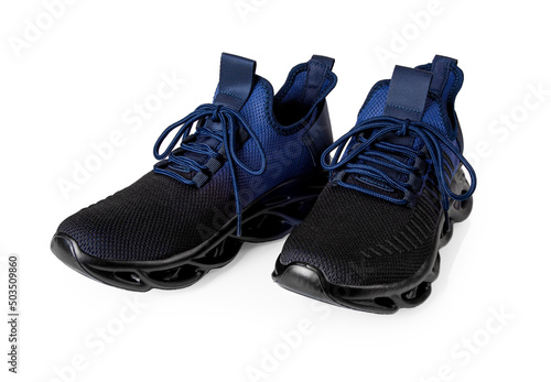 Pair of new grooved sneakers isolated on a white background. Textile sport shoes with laced fastening cutout. Black blue mesh sneakers for fitness and active lifestyle. Sport shoes concept.