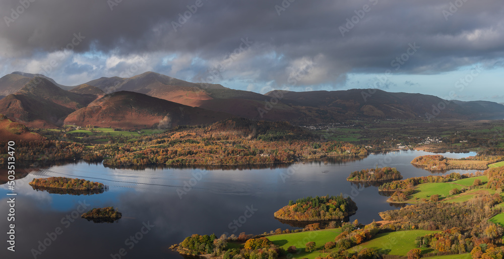 Beautiful landscape Autumn image of view from Walla Crag in Lake District, over Derwentwater looking towards Catbells and distant mountains with stunning Fall colors and light