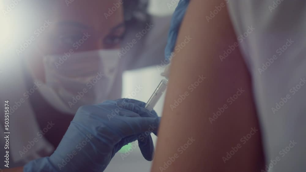 Face woman doctor making vaccine injection to patient visiting hospital close up Face woman doctor making vaccine injection to patient visiting hospital close up