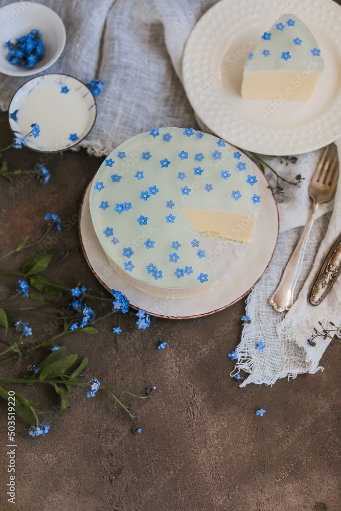 Mousse cake with blue jelly and natural forget-me-not flowers. Beautiful desserts with spring flowers. Mousse cake with blue jelly and natural forget-me-not flowers. Beautiful desserts with spring flowers.