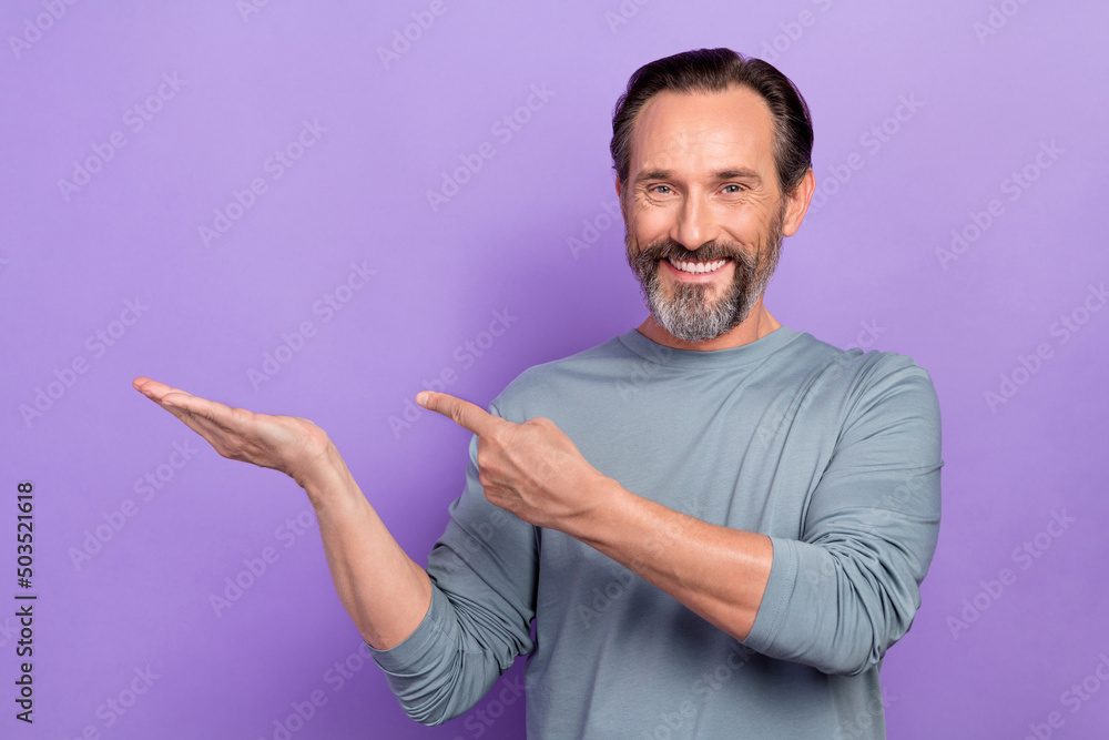 Photo of handsome cheerful male advertising product object on sale discount isolated on violet color background Photo of handsome cheerful male advertising product object on sale discount isolated on violet color background