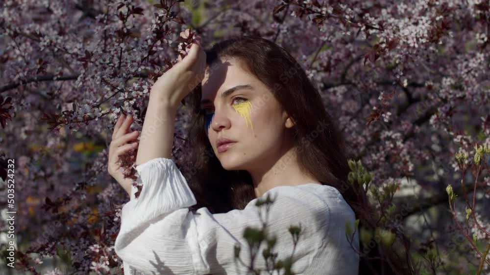 Young attractive girl portrait with Ukrainian flag in the spring cherry garden Young attractive girl portrait with Ukrainian flag in the spring cherry garden