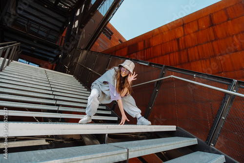 woman dancing on urban spat. Girl performing hip hop dance style having fun freestyle dancer in urban city photo