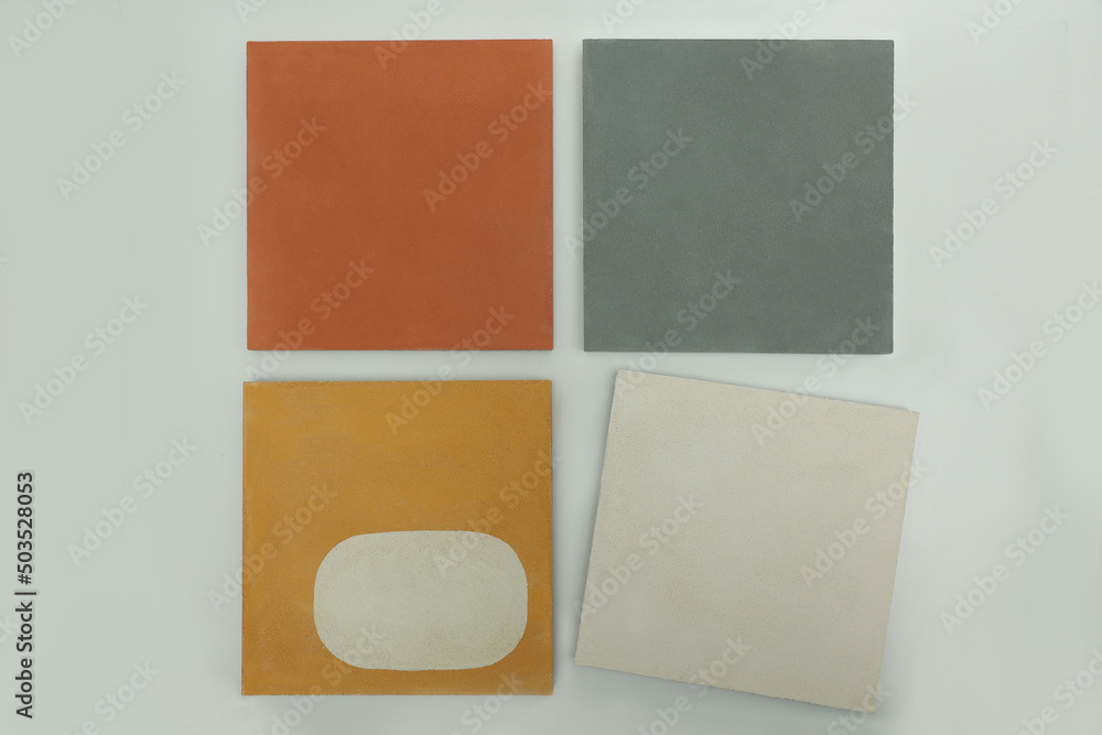 Fototapeta premium Demonstration layout of decorative concrete tiles for home facades and office spaces of bright colors. Stone tiles in grey orange yellow and white colours on the exhibition stand