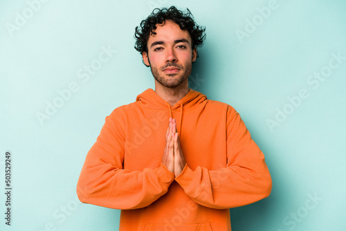 Foto Young caucasian man isolated on white background praying, showing devotion, religious person looking for divine inspiration