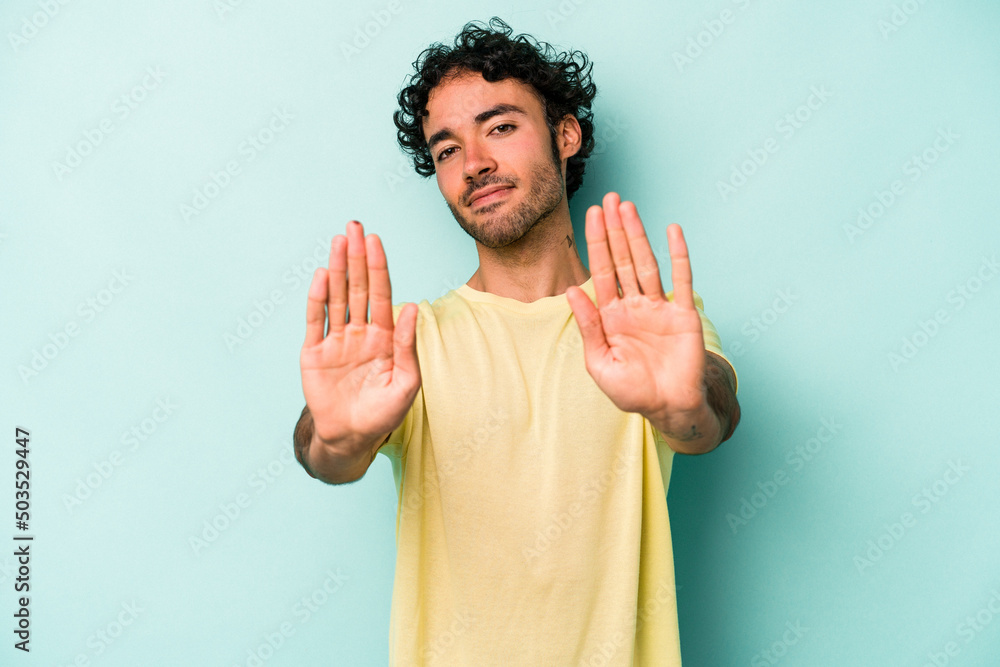 Naklejka premium Young caucasian man isolated on white background standing with outstretched hand showing stop sign, preventing you.