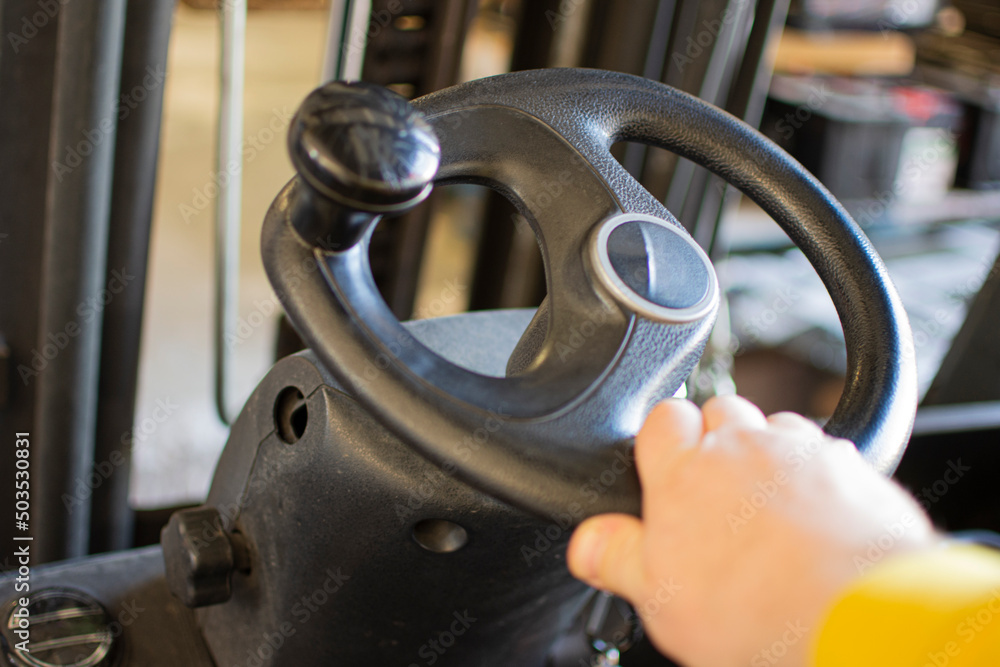 Hand rotates the steering wheel of the electric forklift, right, left. Turn and steer the driving machinery. Hand rotates the steering wheel of the electric forklift, right, left. Turn and steer the driving machinery.