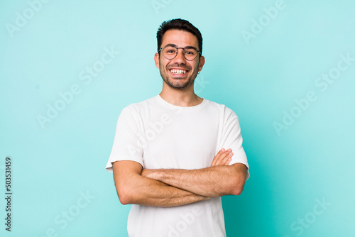 young handsome hicpanic man looking like a happy, proud and satisfied achiever smiling with arms crossed