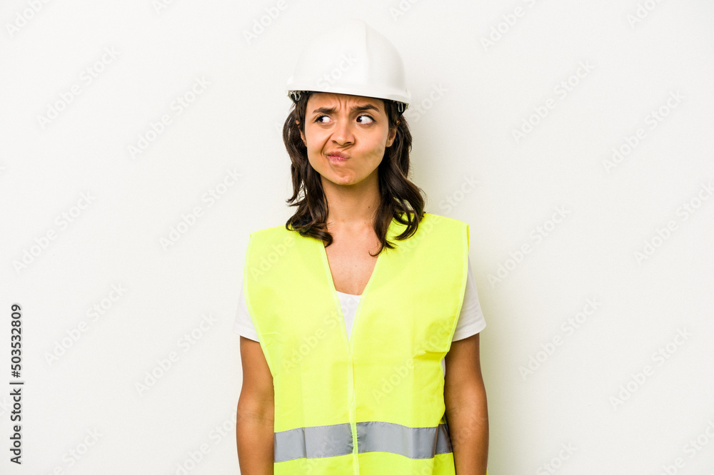 Young laborer hispanic woman isolated on white background confused, feels doubtful and unsure. Young laborer hispanic woman isolated on white background confused, feels doubtful and unsure.