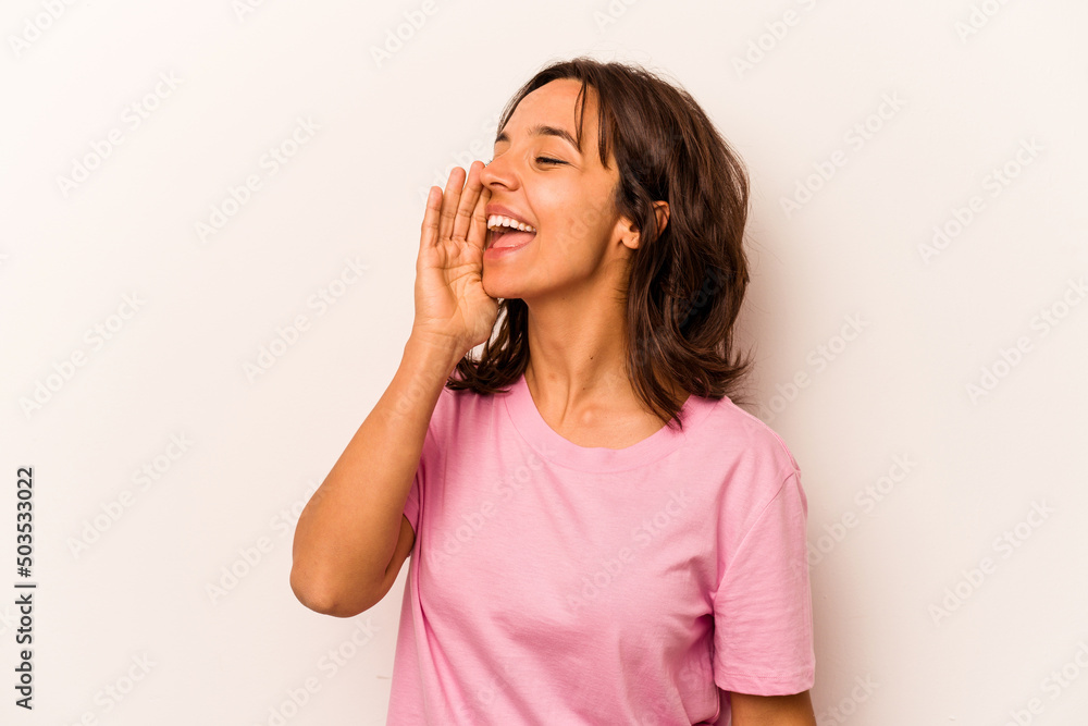 Young hispanic woman isolated on white background shouting and holding palm near opened mouth. Young hispanic woman isolated on white background shouting and holding palm near opened mouth.