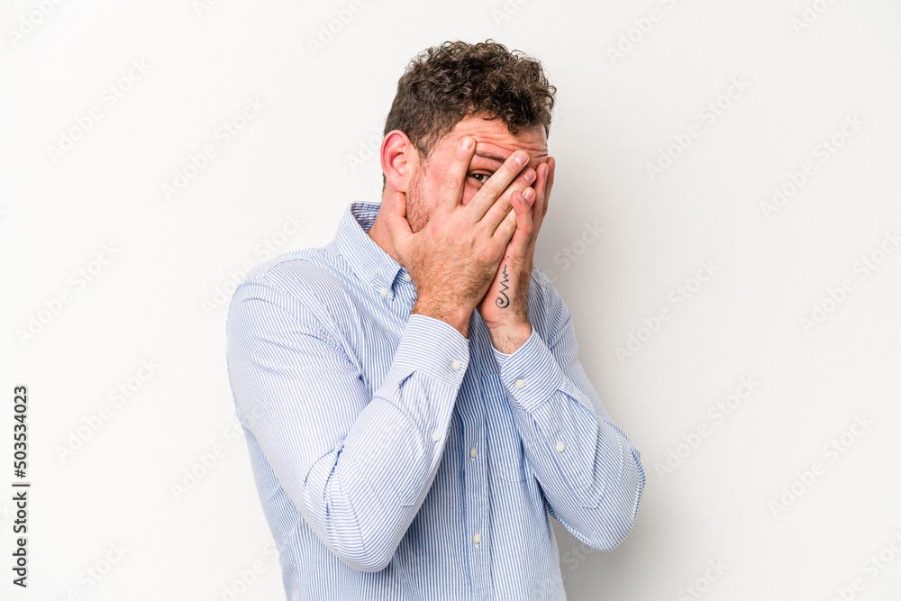 Young caucasian man isolated on white background blink through fingers frightened and nervous. Young caucasian man isolated on white background blink through fingers frightened and nervous.