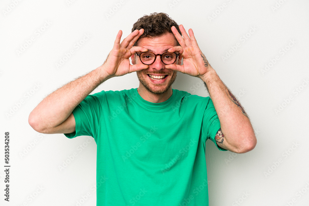 Young caucasian man isolated on white background showing okay sign over eyes Young caucasian man isolated on white background showing okay sign over eyes