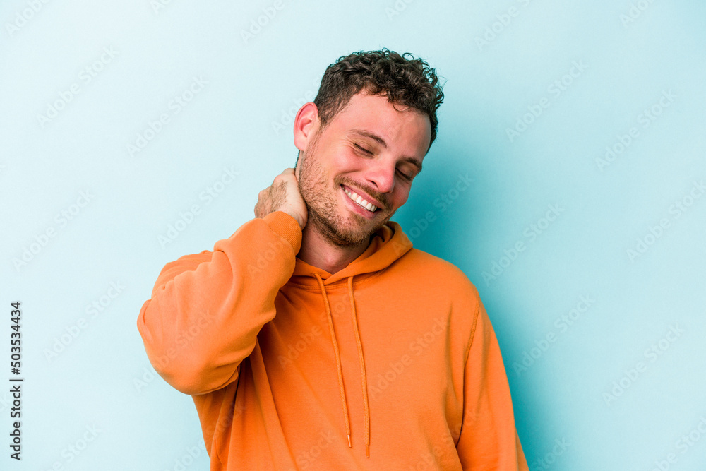 Young caucasian man isolated on blue background having a neck pain due to stress, massaging and touching it with hand. Young caucasian man isolated on blue background having a neck pain due to stress, massaging and touching it with hand.