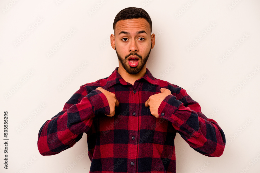 Young hispanic man isolated on white background surprised pointing with finger, smiling broadly. Young hispanic man isolated on white background surprised pointing with finger, smiling broadly.