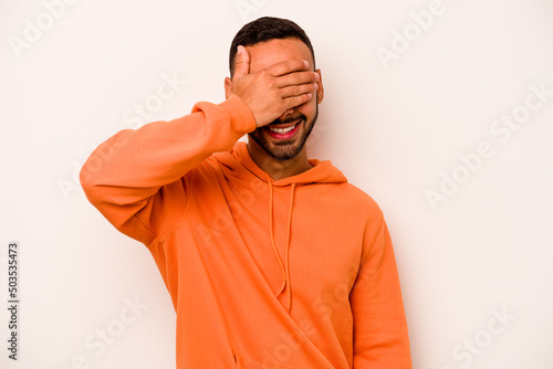 Young hispanic man isolated on white background covers eyes with hands, smiles broadly waiting for a surprise. © Asier