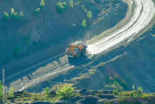 The process of irrigating a technical road with an irrigation automobile. The irrigation vehicle on the basis of a large quarry truck in operation. Dust suppression in a mining quarry.