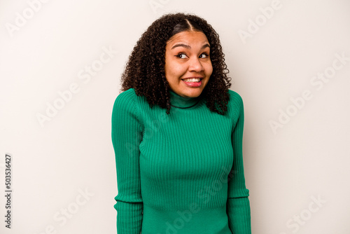 Young African American woman isolated on white background laughs and closes eyes, feels relaxed and happy. © Asier