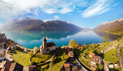 Stunning idylic nature scenery of lake Brienz with turquoise waters. Switzerland, Bern canton. Aerial view with little church in the morning light photo