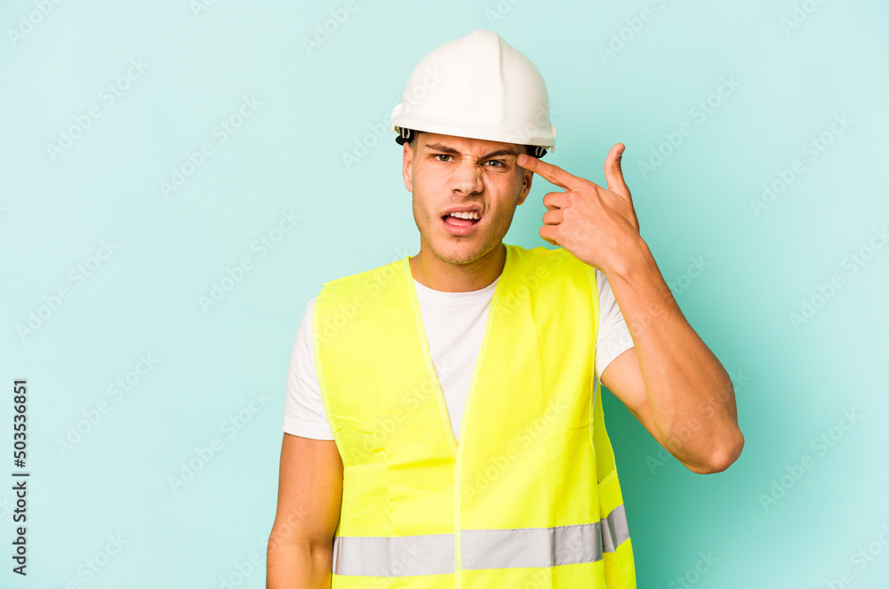 Young laborer caucasian man isolated on blue background showing a disappointment gesture with forefinger.