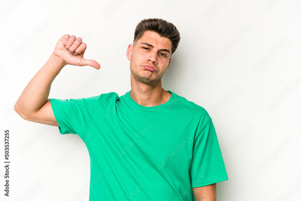 Young caucasian man isolated on white background showing a dislike gesture, thumbs down. Disagreement concept. Young caucasian man isolated on white background showing a dislike gesture, thumbs down. Disagreement concept.
