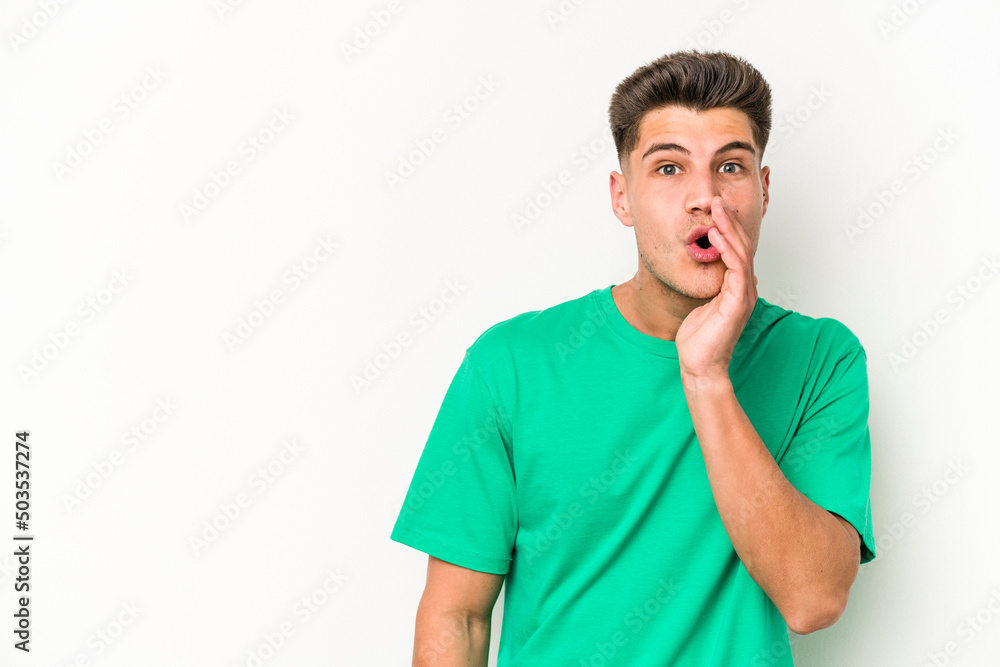 Young caucasian man isolated on white background is saying a secret hot braking news and looking aside Young caucasian man isolated on white background is saying a secret hot braking news and looking aside