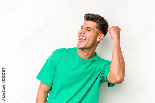 Young caucasian man isolated on white background celebrating a victory, passion and enthusiasm, happy expression.